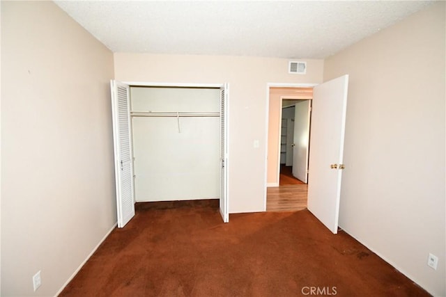 unfurnished bedroom with carpet, a closet, and visible vents