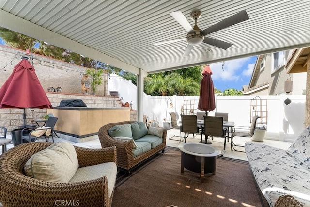 view of patio / terrace with a fenced backyard, an outdoor hangout area, a ceiling fan, outdoor dry bar, and outdoor dining space