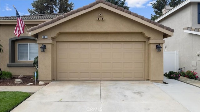 exterior space featuring a garage, a tile roof, and stucco siding