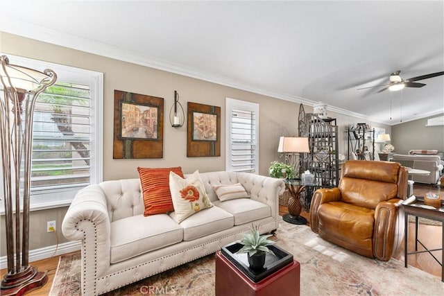 living room featuring ceiling fan, ornamental molding, wood finished floors, and baseboards