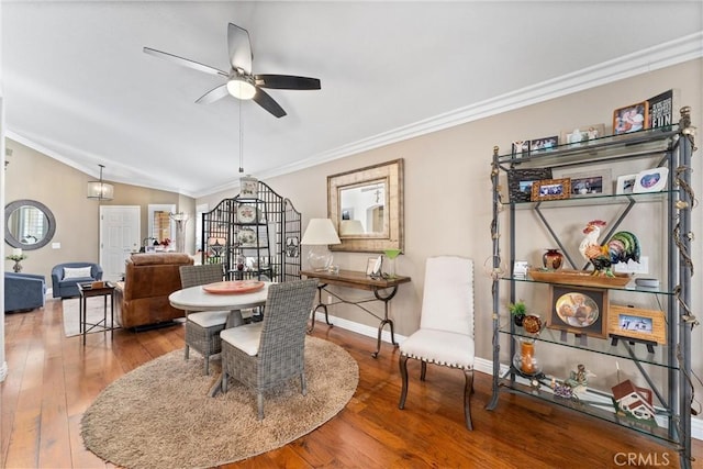 dining space with vaulted ceiling, ornamental molding, and wood finished floors