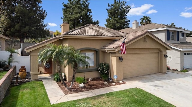 mediterranean / spanish home featuring a chimney, stucco siding, an attached garage, fence, and a tiled roof