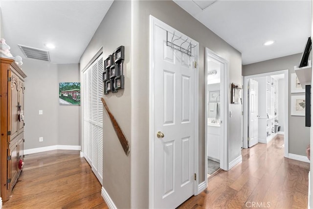 hall with baseboards, recessed lighting, visible vents, and light wood-style floors