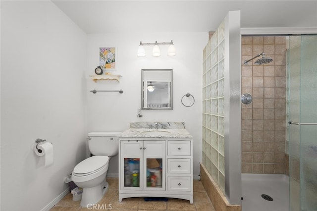 full bath featuring toilet, vanity, baseboards, a tile shower, and tile patterned floors