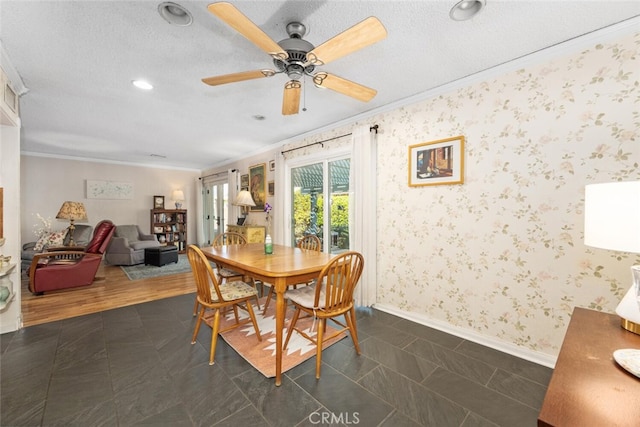 dining area with a textured ceiling, ornamental molding, and wallpapered walls