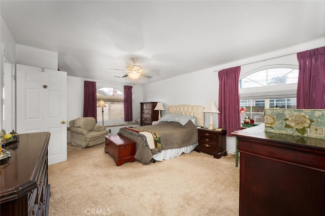 bedroom featuring ceiling fan, multiple windows, and light colored carpet