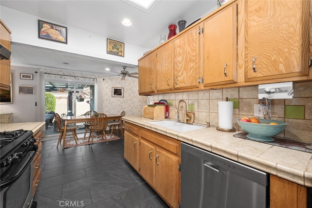 kitchen featuring a sink, a ceiling fan, stainless steel dishwasher, tasteful backsplash, and gas stove