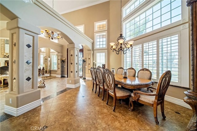 tiled dining room with a healthy amount of sunlight, baseboards, decorative columns, arched walkways, and crown molding