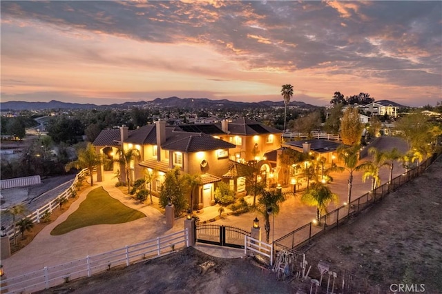 exterior space with a fenced front yard, stucco siding, a mountain view, and a gate