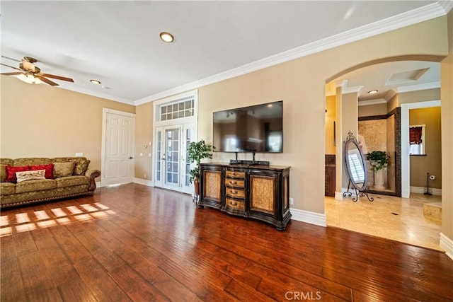 living area featuring baseboards, hardwood / wood-style floors, and ornamental molding