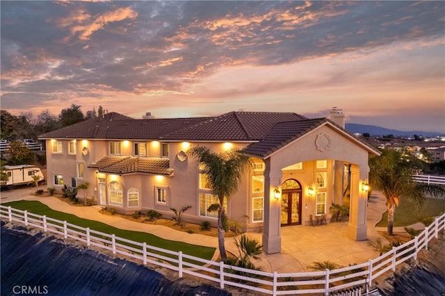 back of house with french doors, a fenced front yard, and stucco siding