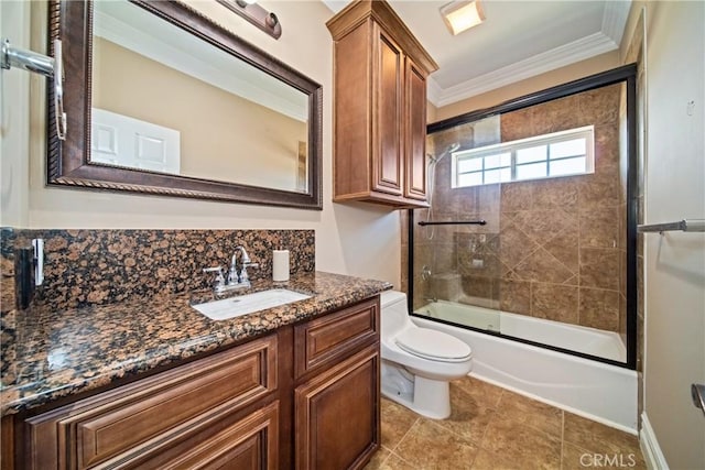 bathroom featuring toilet, ornamental molding, combined bath / shower with glass door, decorative backsplash, and vanity