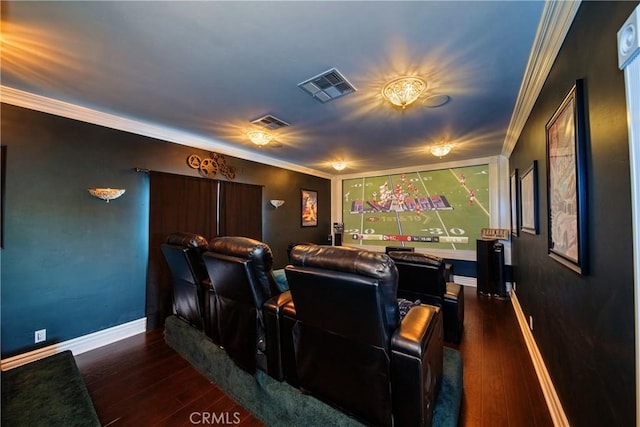 cinema room featuring visible vents, wood-type flooring, and ornamental molding