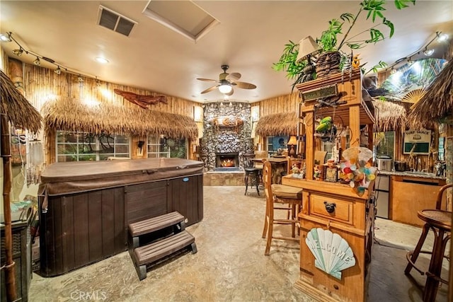 interior space with a ceiling fan, a fireplace, and visible vents