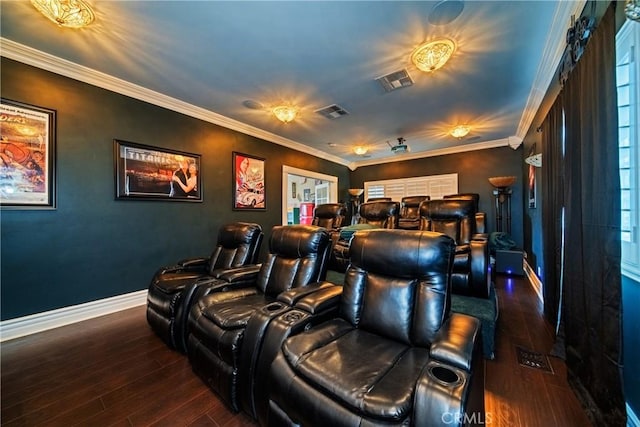 home theater room featuring visible vents, wood finished floors, and ornamental molding