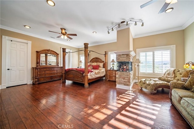 bedroom with a fireplace, crown molding, baseboards, and wood-type flooring