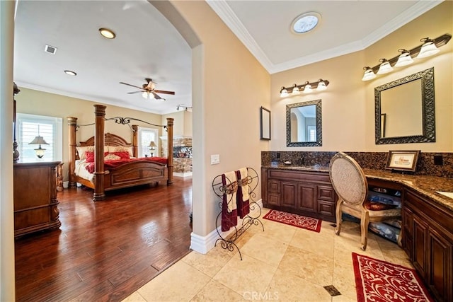 ensuite bathroom featuring wood finished floors, visible vents, double vanity, ornamental molding, and ensuite bathroom