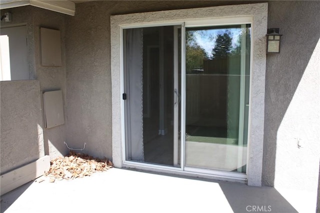 property entrance with stucco siding