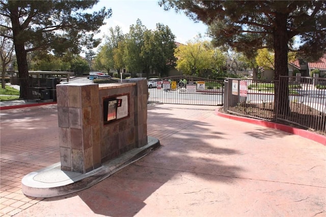 view of road featuring a gate, a gated entry, and curbs