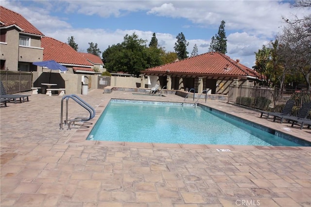 pool featuring a patio area and fence