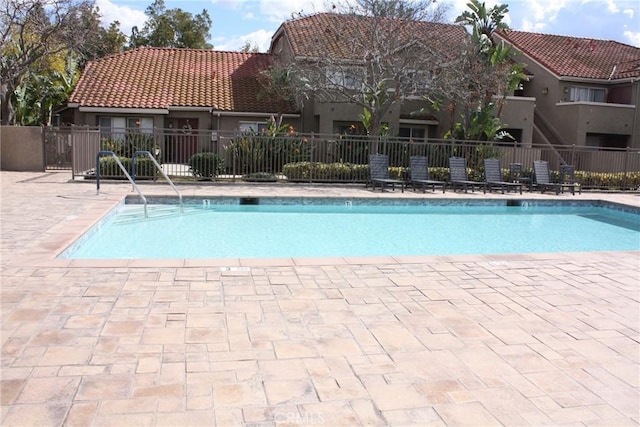 pool featuring fence and a patio