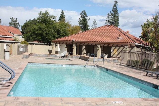 community pool featuring a patio and fence