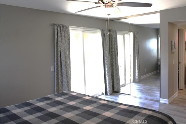 unfurnished bedroom featuring a ceiling fan, baseboards, and wood finished floors