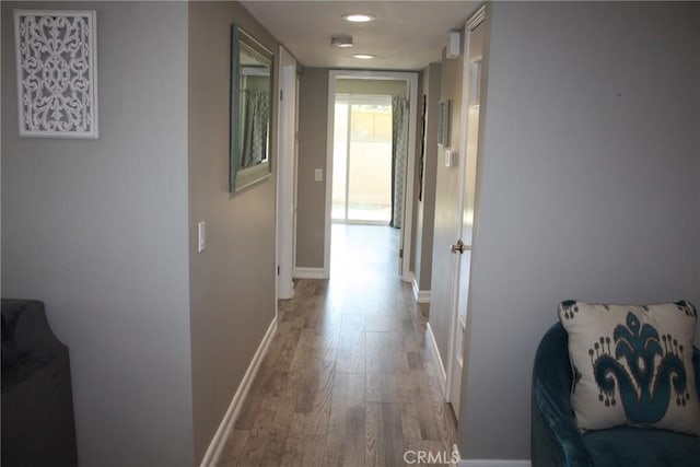 hall with light wood finished floors, recessed lighting, and baseboards