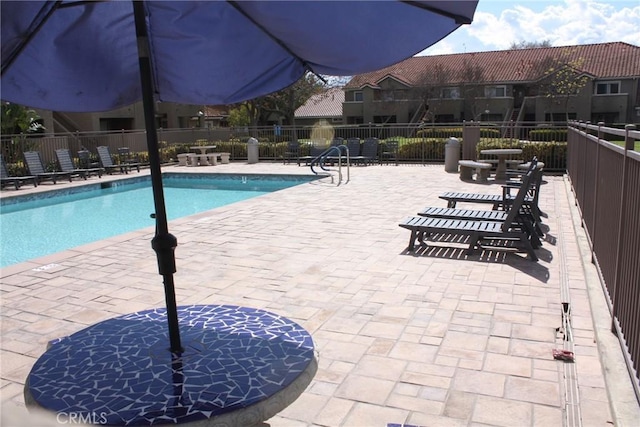 community pool with fence and a patio