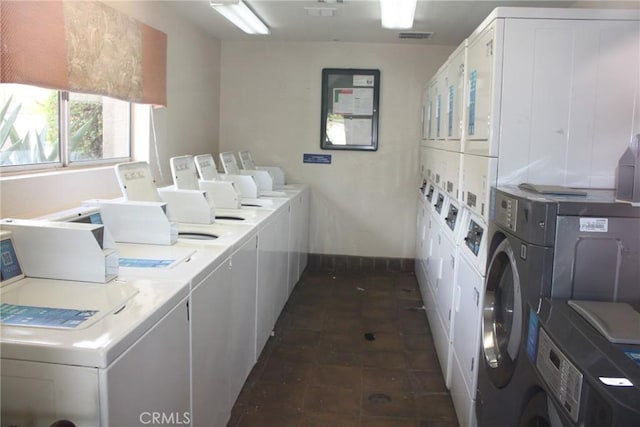 shared laundry area featuring independent washer and dryer, visible vents, baseboards, and stacked washer and clothes dryer