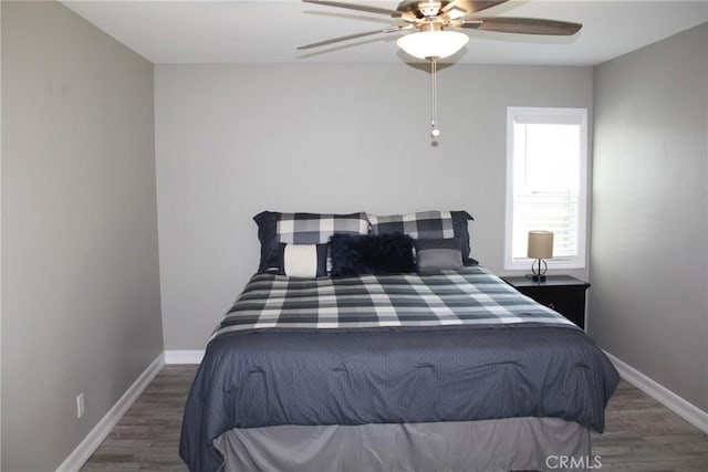 bedroom featuring a ceiling fan, baseboards, and wood finished floors