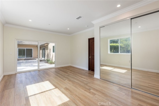 unfurnished bedroom with light wood-type flooring, visible vents, ornamental molding, a closet, and baseboards