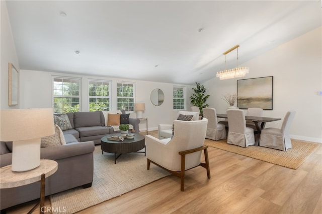 living area featuring lofted ceiling, light wood-style flooring, and baseboards