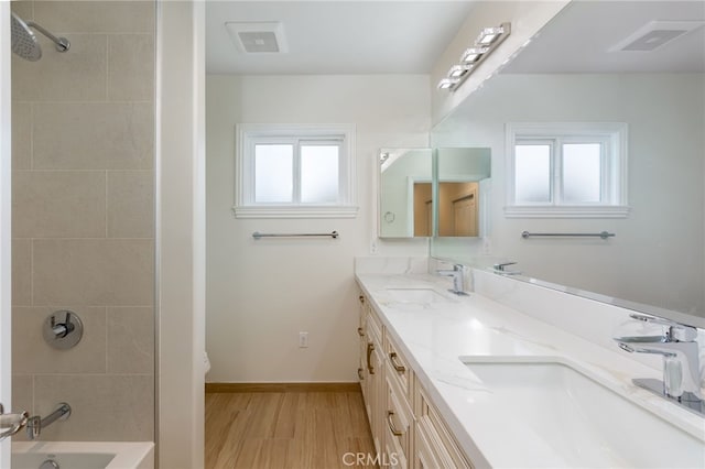 full bathroom with a sink, baseboards, wood finished floors, and double vanity