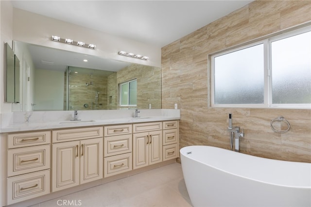 full bath featuring double vanity, a stall shower, tile walls, and a sink