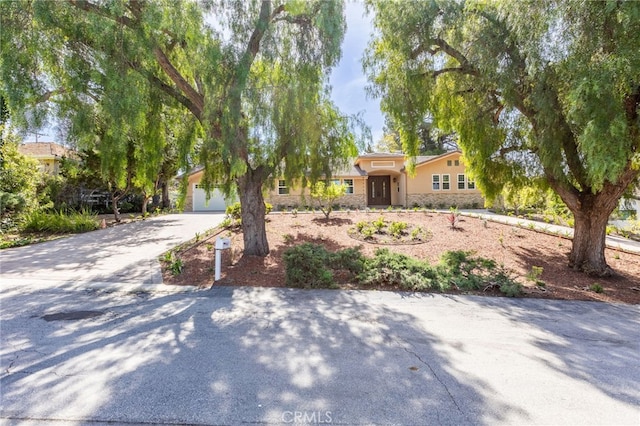 4 Singletree Ln, Rolling Hills Estates, CA 90274 - view of front facade with stone siding, stucco siding, and driveway