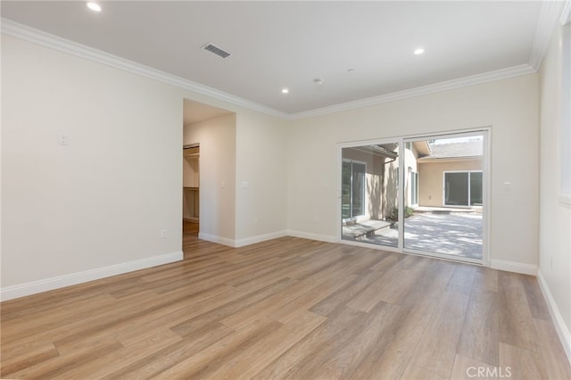 empty room featuring visible vents, baseboards, crown molding, and light wood finished floors