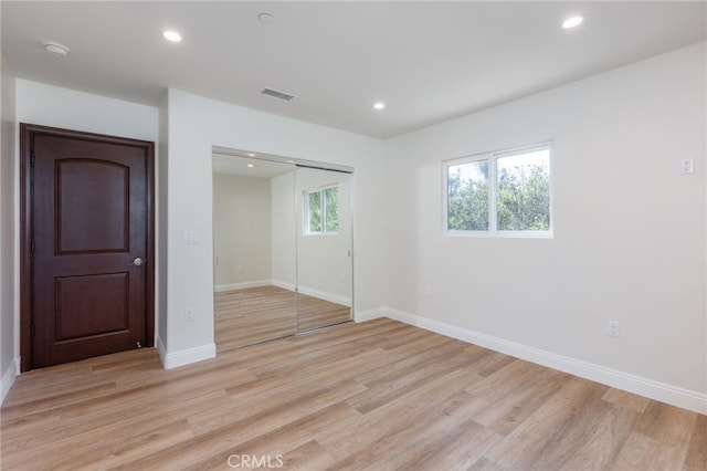 unfurnished bedroom featuring a closet, visible vents, recessed lighting, and light wood-style floors