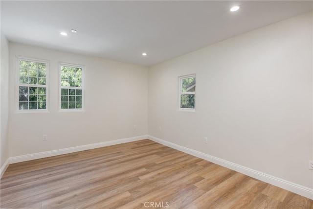 spare room featuring recessed lighting, baseboards, and light wood-type flooring