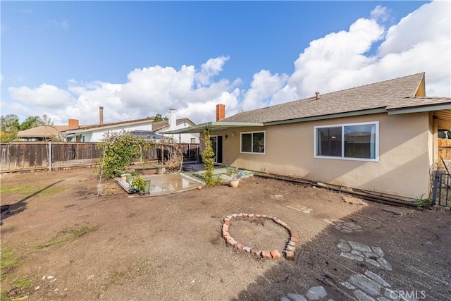 back of house with a patio area, a fenced backyard, and stucco siding