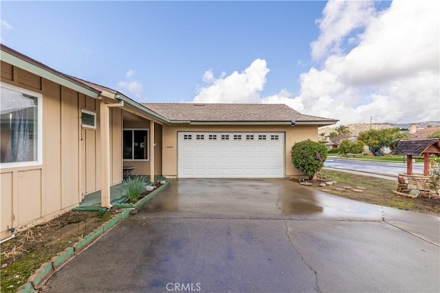 view of front of house with a garage, driveway, board and batten siding, and stucco siding