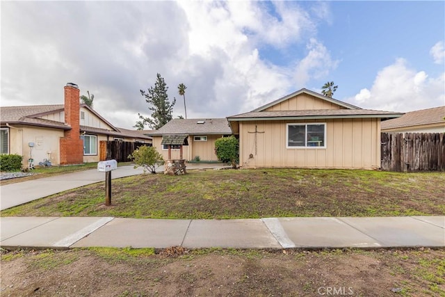 ranch-style home with fence and a front yard