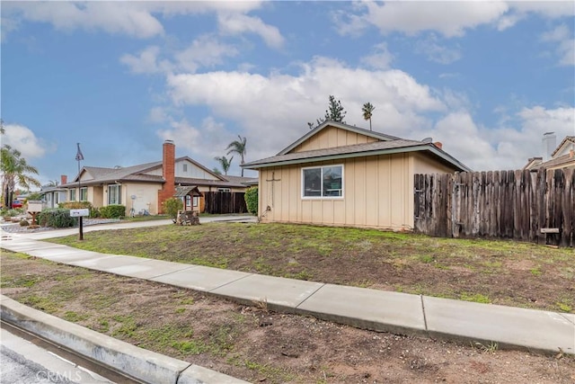 view of front of house featuring fence and a front lawn