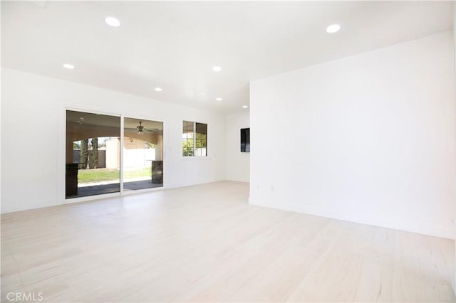 empty room with light wood-type flooring, a ceiling fan, and recessed lighting