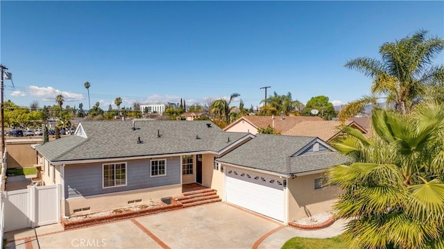 single story home featuring driveway, roof with shingles, an attached garage, and fence