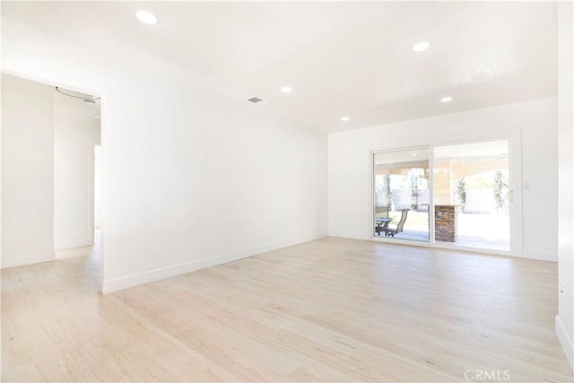 spare room with light wood-type flooring, baseboards, and recessed lighting