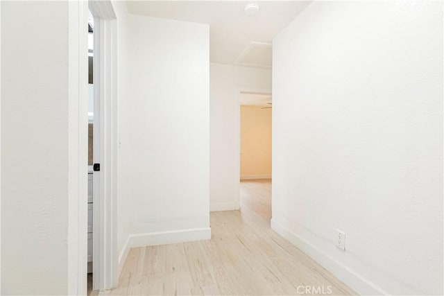 hallway featuring baseboards and wood finished floors