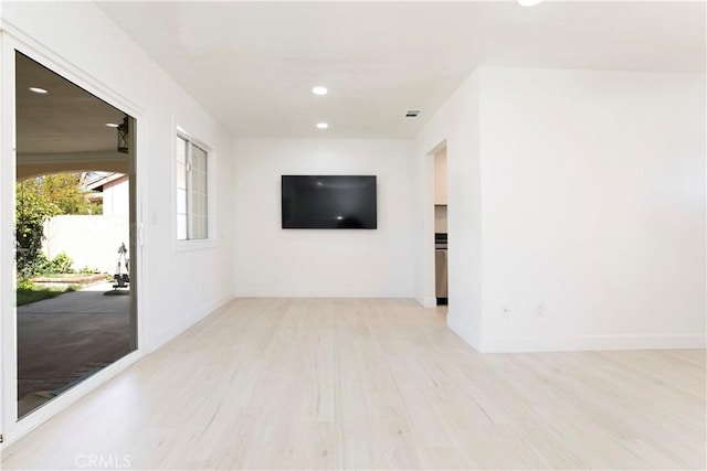 unfurnished room featuring baseboards, light wood-type flooring, visible vents, and recessed lighting