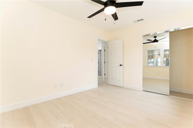 unfurnished bedroom with light wood finished floors, baseboards, visible vents, and ceiling fan