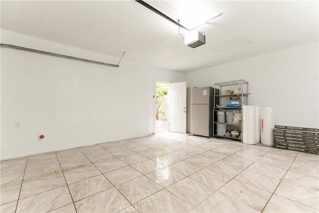 garage featuring freestanding refrigerator and a garage door opener